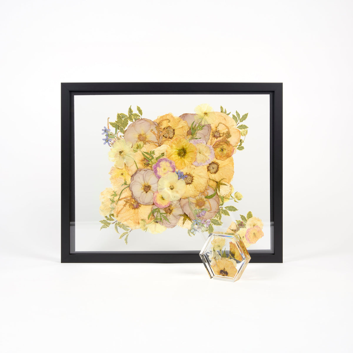 A preservation package featuring a black bouquet frame and a pressed flower ring dish with pink, purple, and coral flowers.