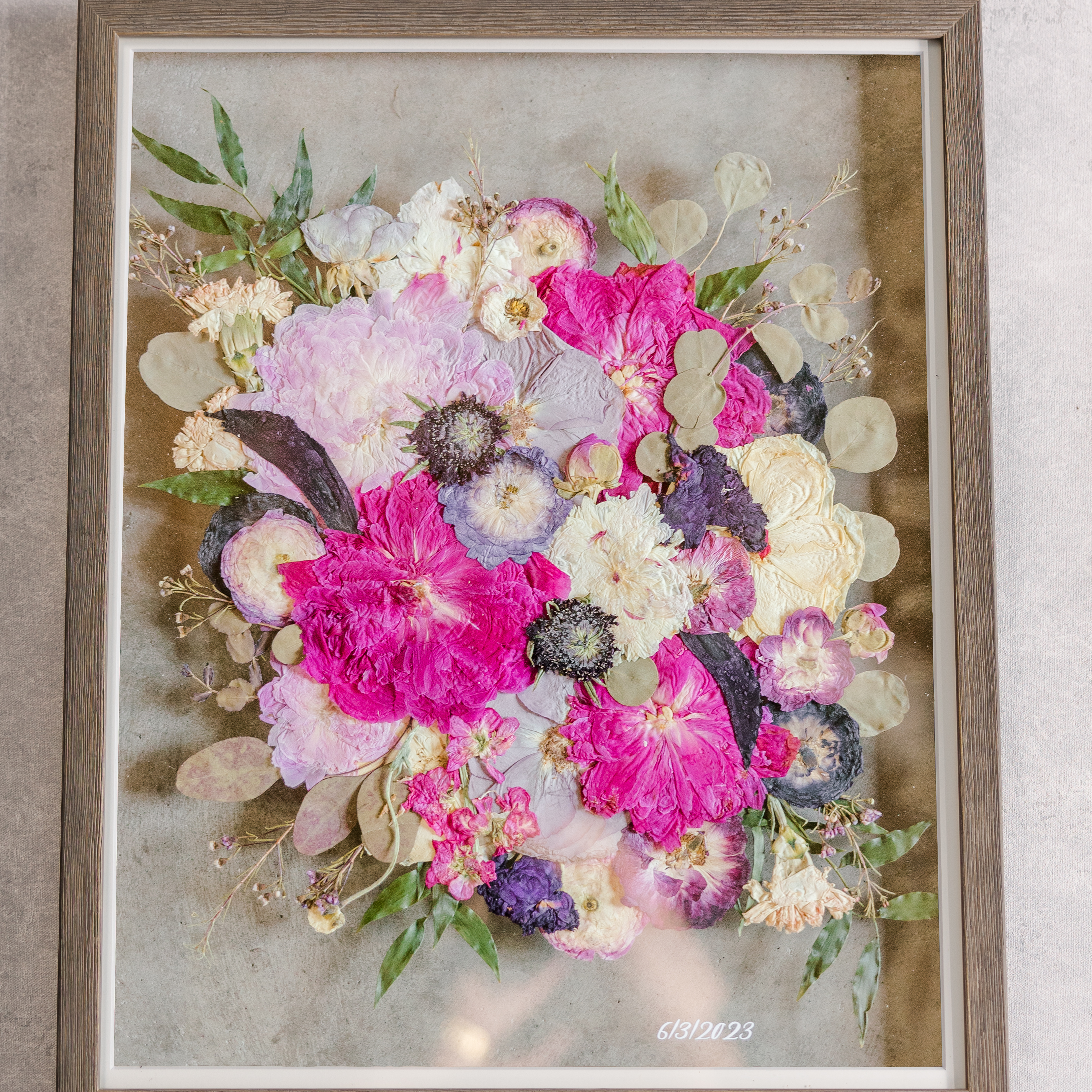 A large wooden frame with bright pink florals inside.