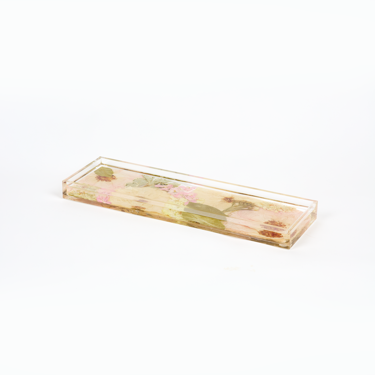 A delicate design of pressed florals in a resin display tray as a part of a wedding bouquet preservation order.