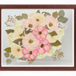 a large walnut colored frame with pink and white pressed florals