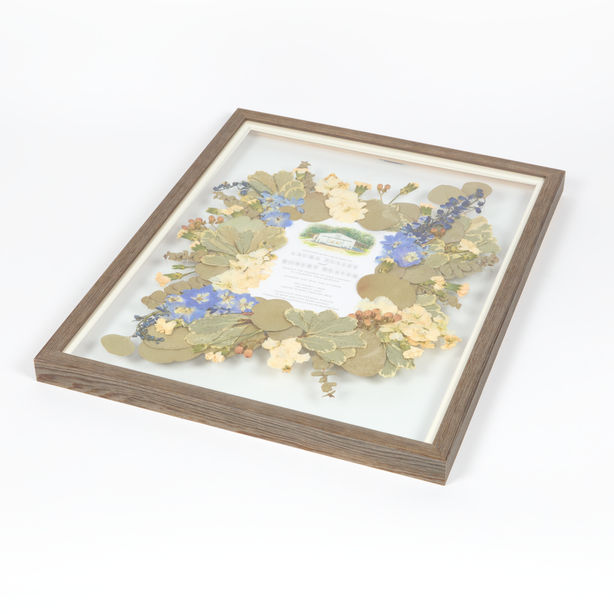 Floral preservation pressed flower frame with white, blue and green pressed florals and an invitation featured in the center. 16x20 barn wood frame design.