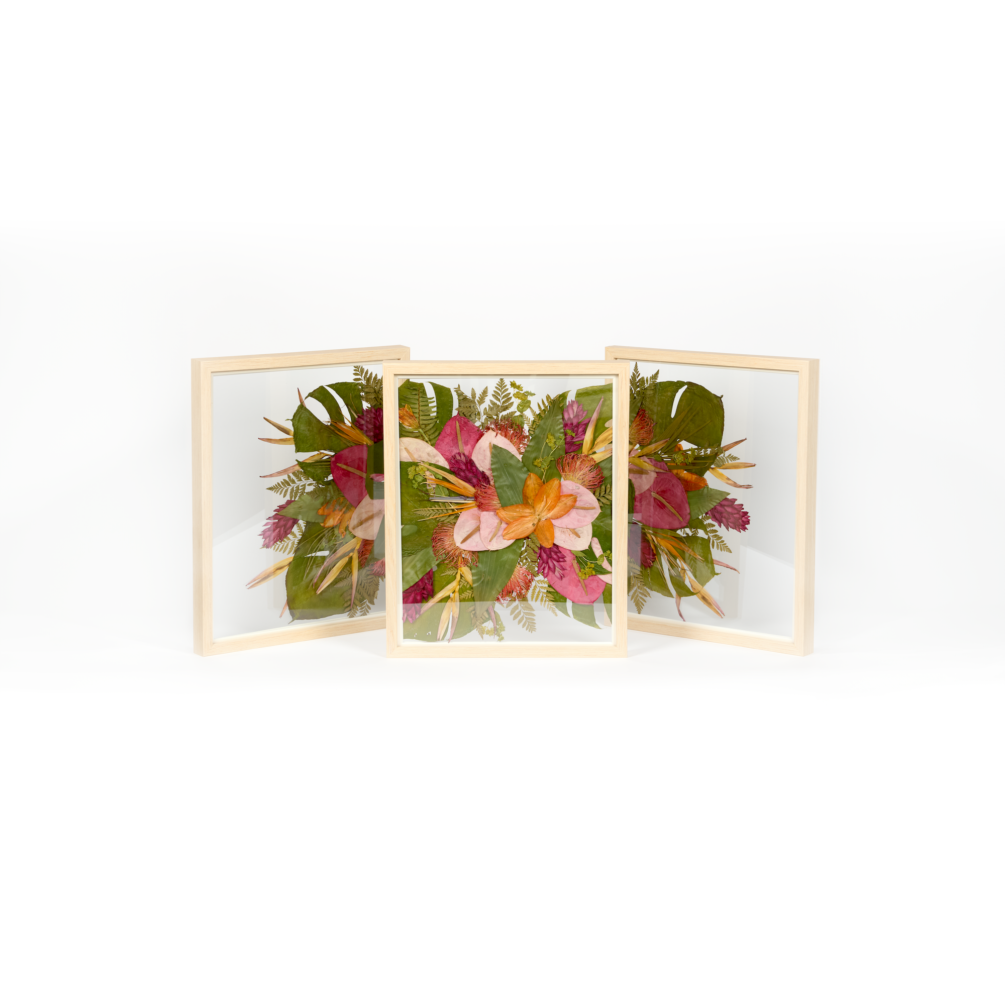 A tropical arrangement of pressed wedding florals including pressed monstera leaves and birds of paradise. The Triptych is designed to have an expansive visual of preserved sentimental flowers.
