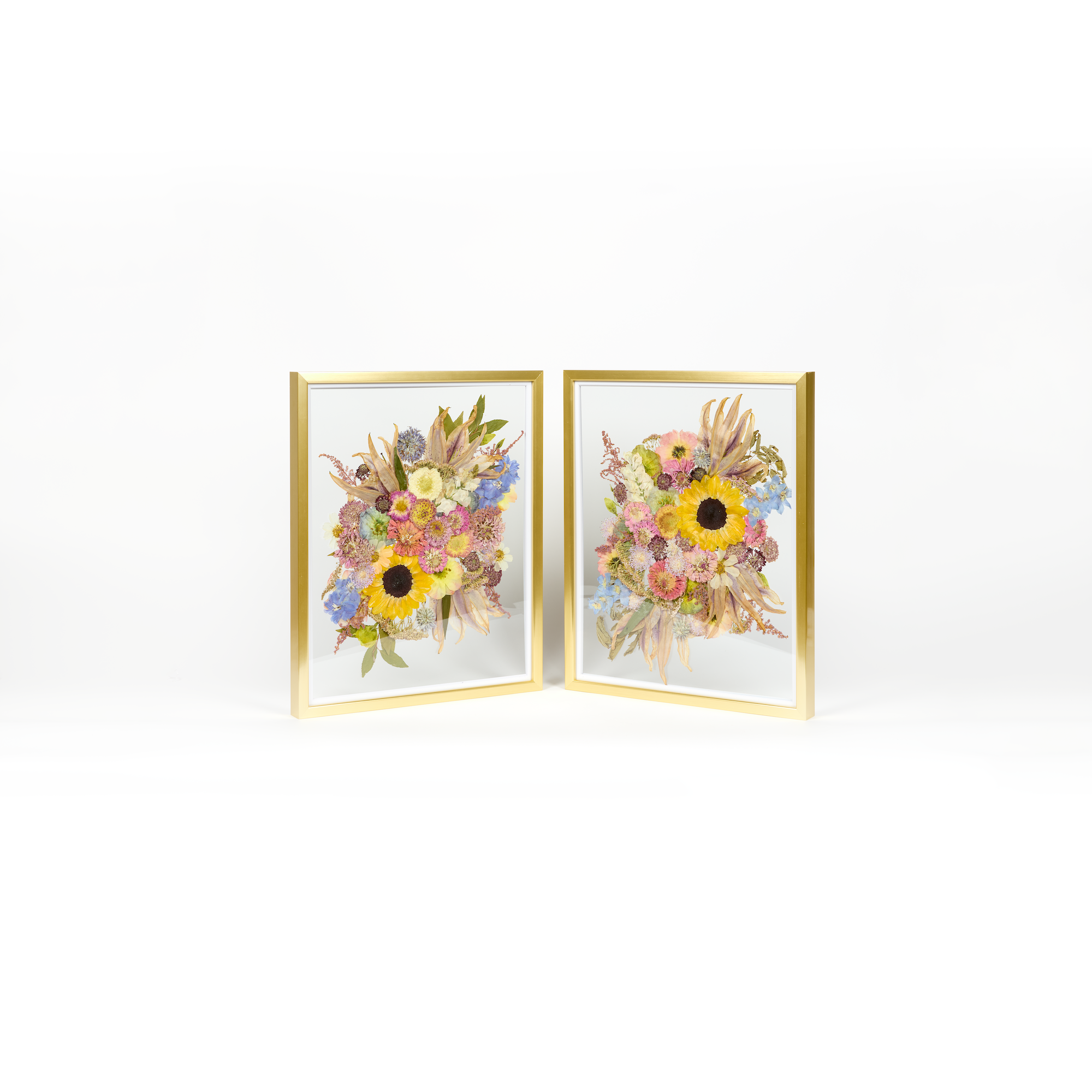 A double pressed flower frame set of wedding florals pressed in gold floating frames. Pressed sunflowers, dahlias, and other florals are featured in these designs.
