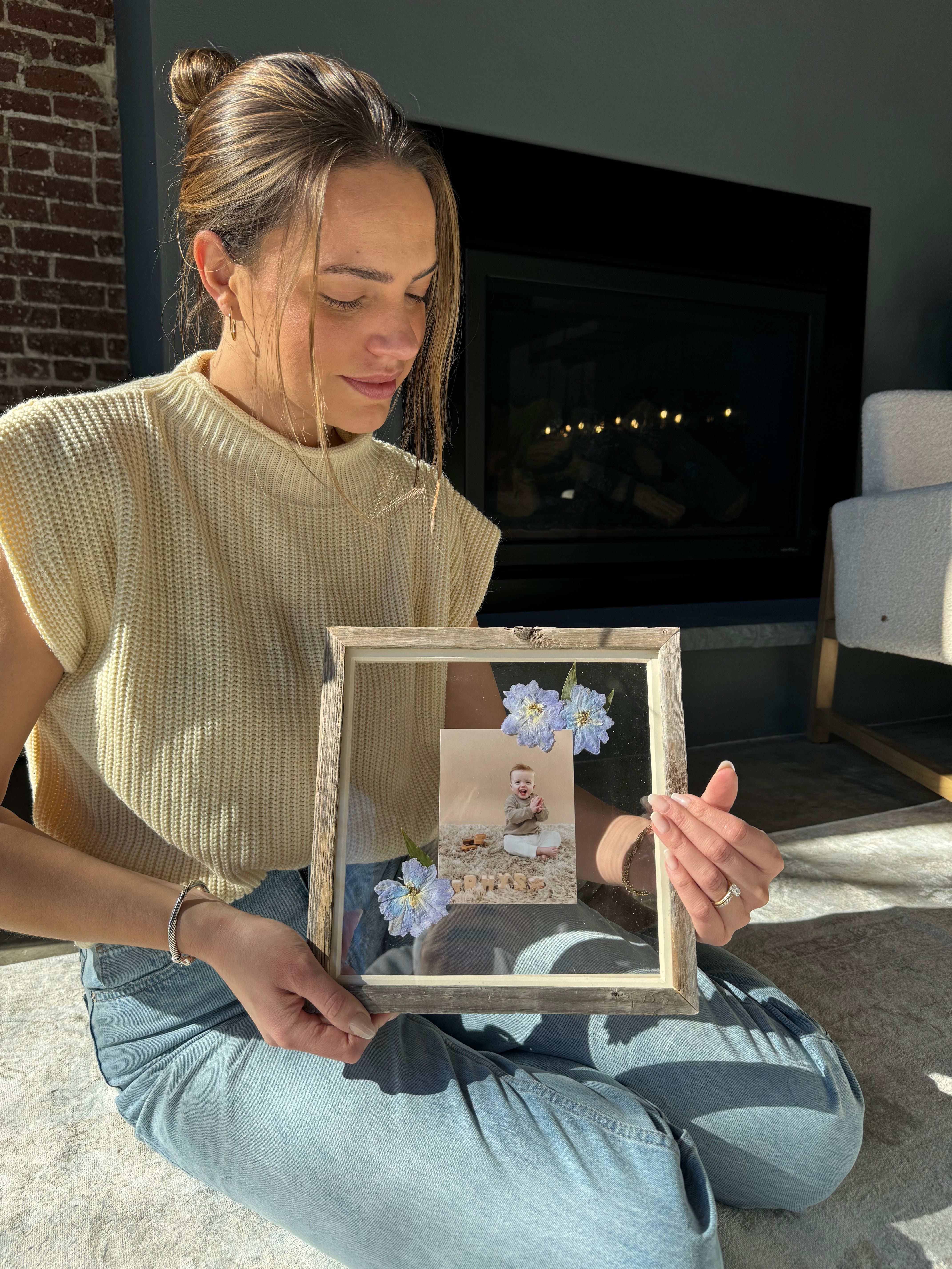 Woman with photograph of baby in a frame with pressed flowers from Element Design Co, Element preservation.