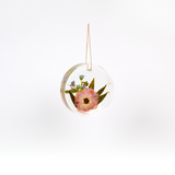Pressed flower resin ornament in a circle shape to as a part of a wedding bouquet preservation order.