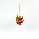 Pressed flower resin ornament in a circle shape to as a part of a wedding bouquet preservation order.
