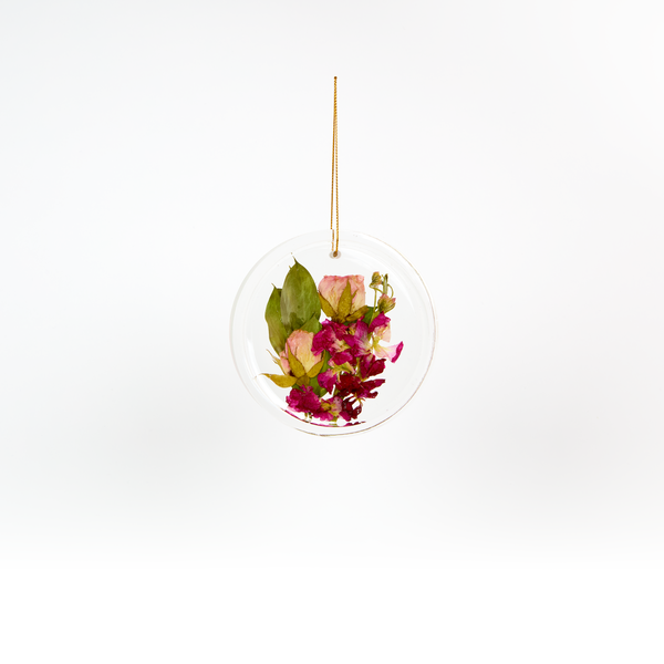 Pressed flower resin ornament in a circle shape to as a part of a wedding bouquet preservation order.