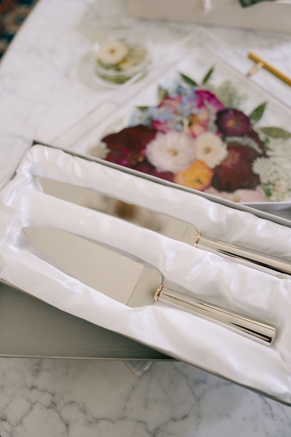 Gold ring handled wedding cake knife and server set from Element Marketplace, shown in gift box, next to resin serving tray