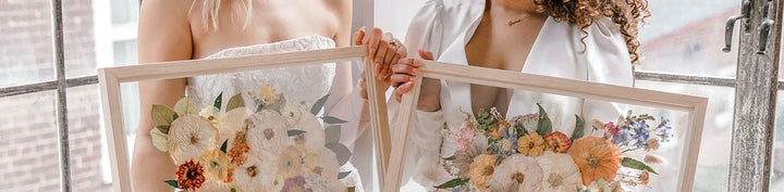 Two brides holding their framed wedding bouquet preservations