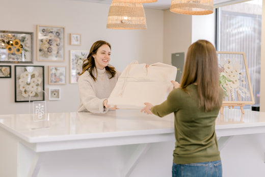 Client picking up flower preservation piece at the Pressed Bouquet Shop