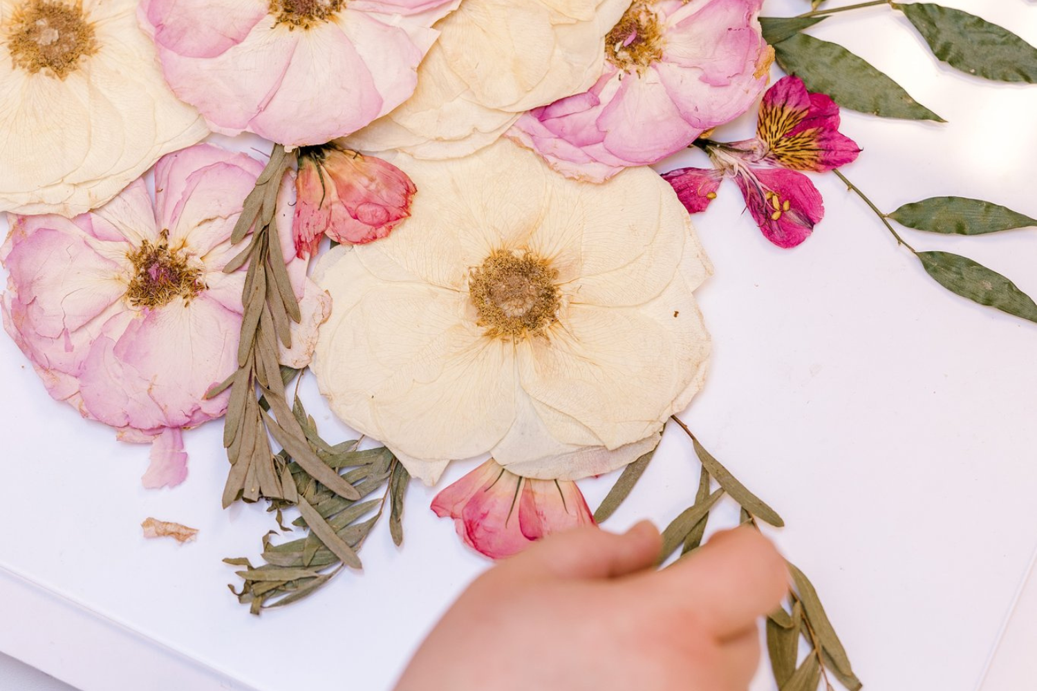 The Element Design team arranges pressed florals into a preserved bouquet design.