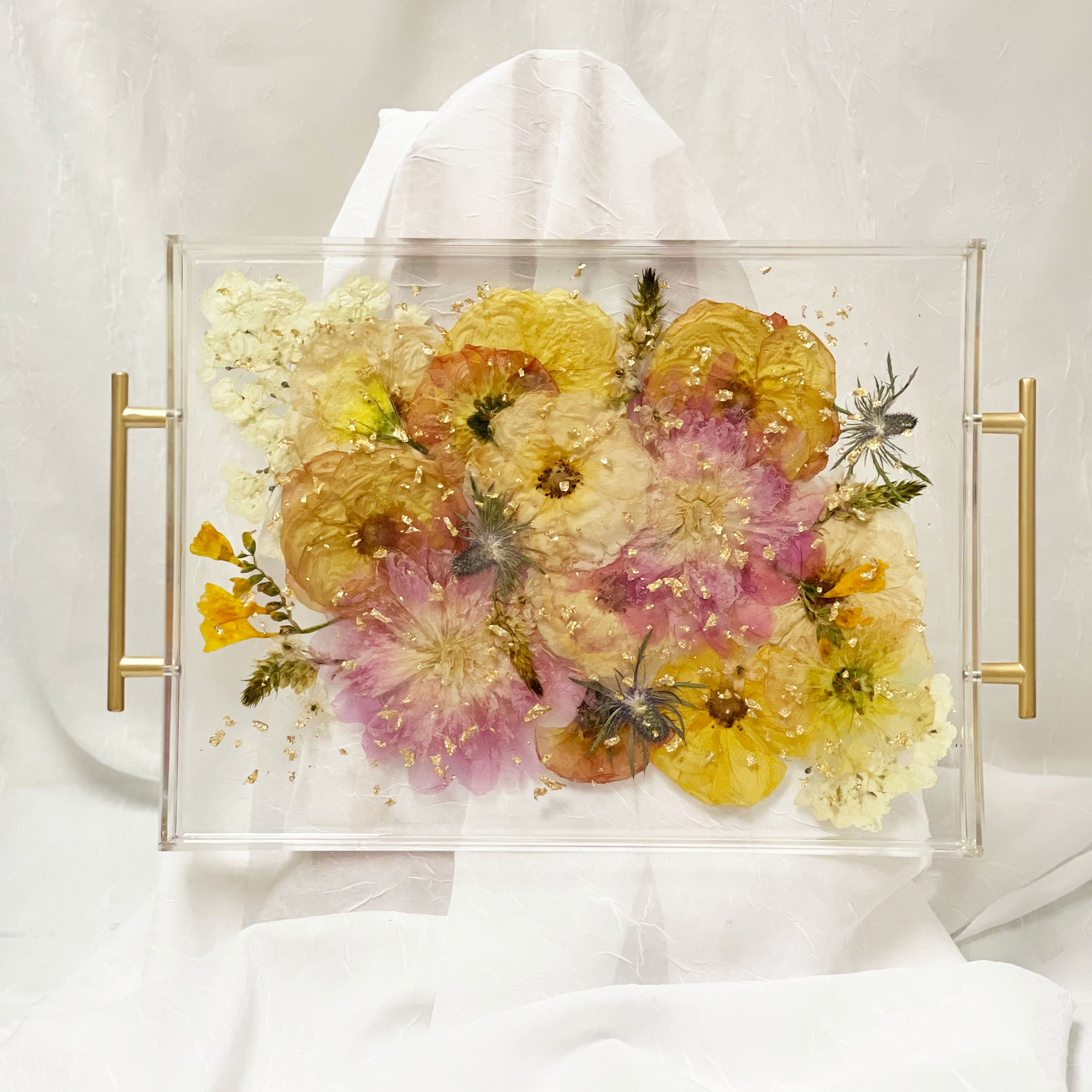 A finished look at a preserved bouquet in a serving tray with gold handles and gold metallic flakes made by Element Preservation.