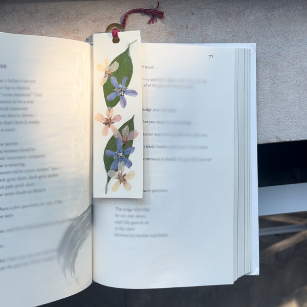 A pressed flower bookmark in a book