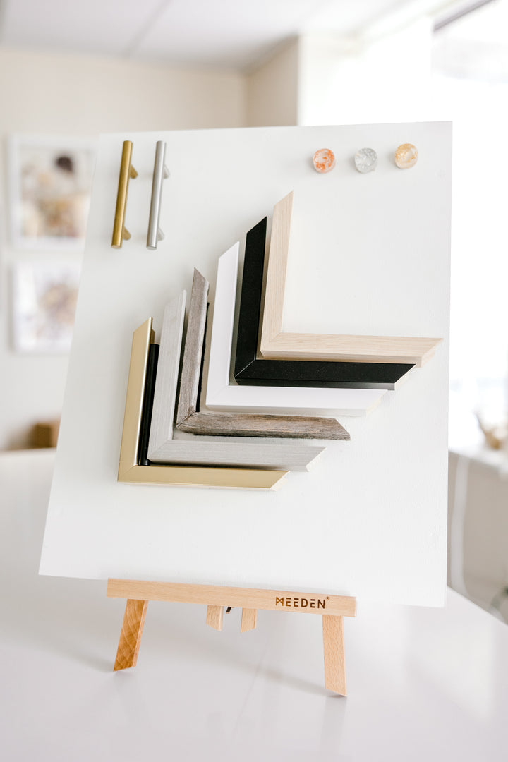 An easel that holds swatches of frame colors and handle colors in a pressed flower shop.