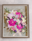 A large wooden frame with bright pink florals inside.