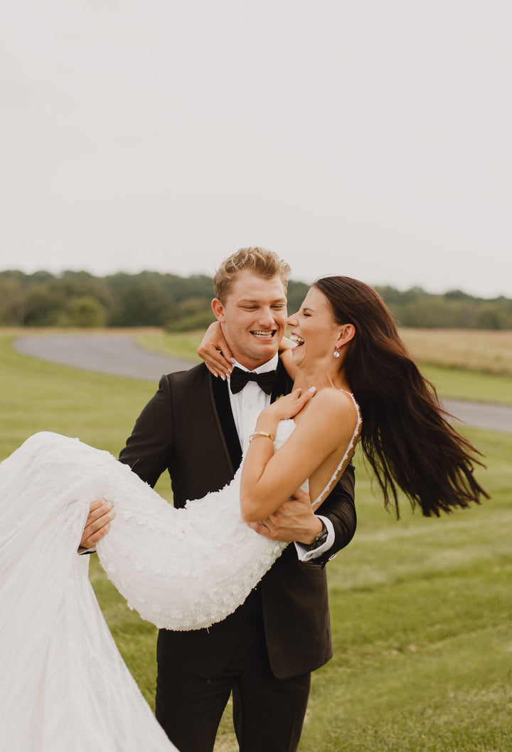 Emily Roebuck Photography capturing smiling couple on wedding day in a green field