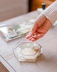 Tossing earrings into a pressed flower ring dish that is hexagon shaped. 