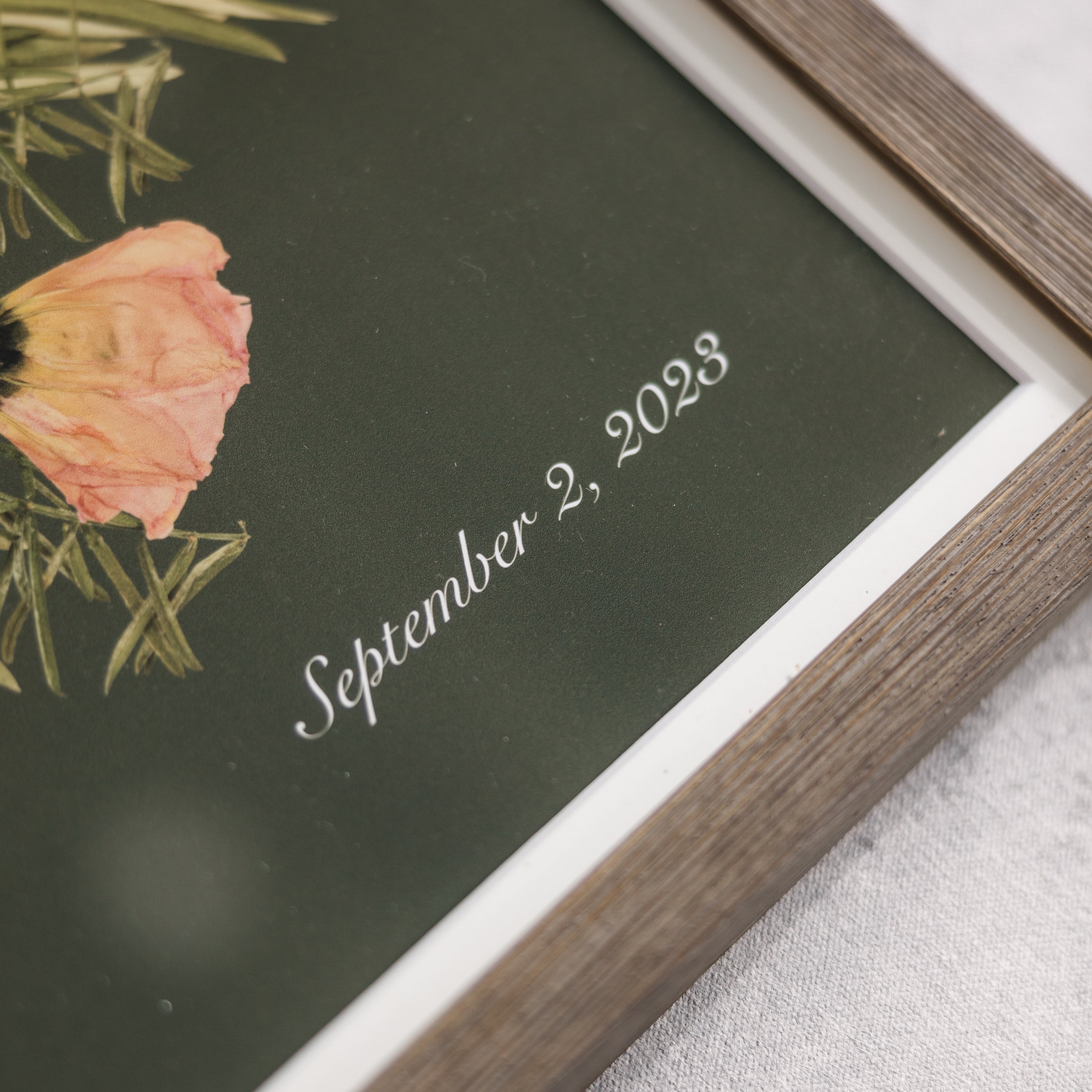 A close up of a pressed flower wood frame. 