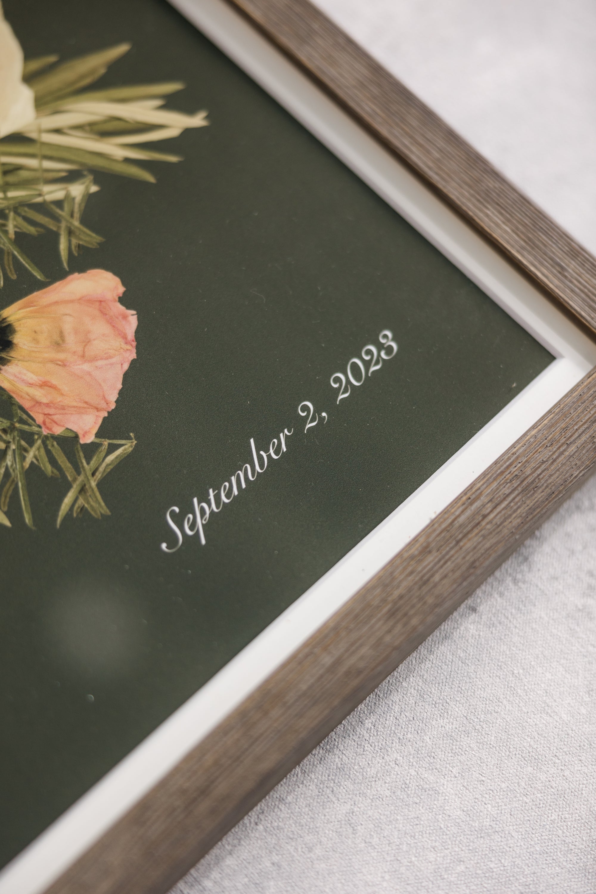 A close up of a pressed flower wood frame. 