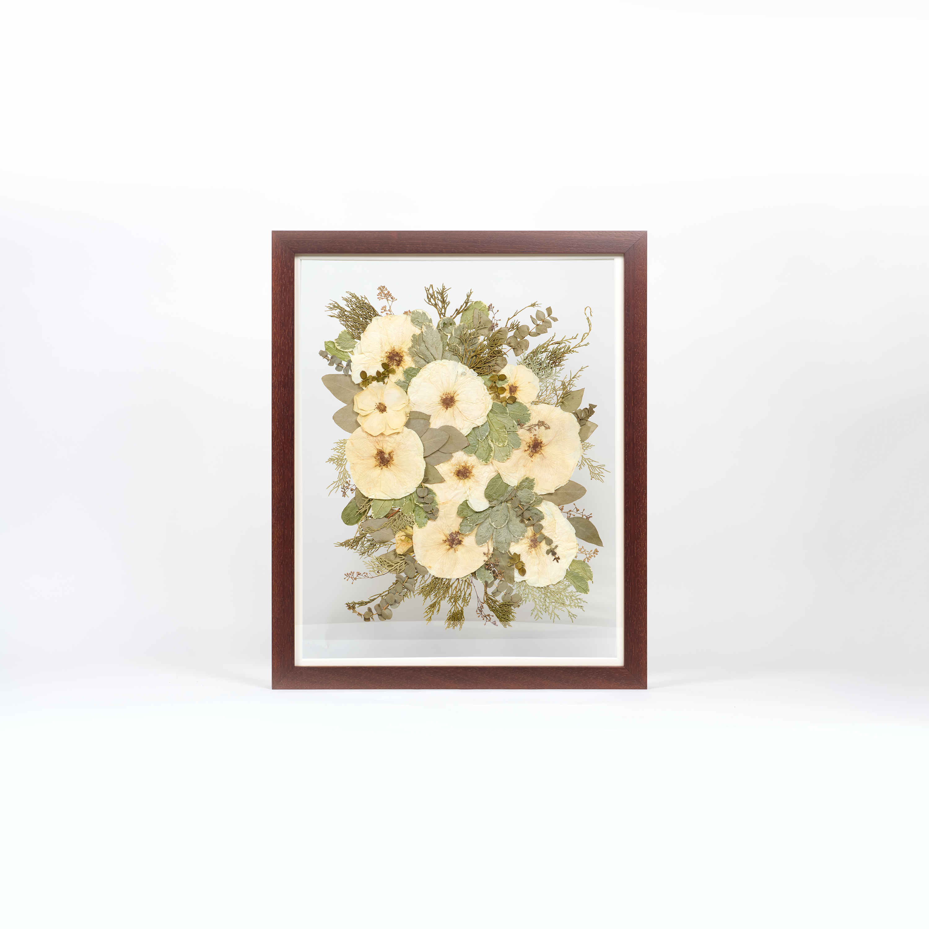 A large pressed bouquet in a brown frame