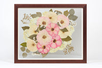 a large walnut colored frame with pink and white pressed florals