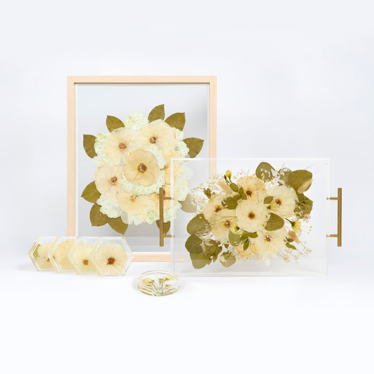 Flower preservation bundle with a pressed floral serving tray, a flower frame, a set of resin floral coasters, and a ring dish. 