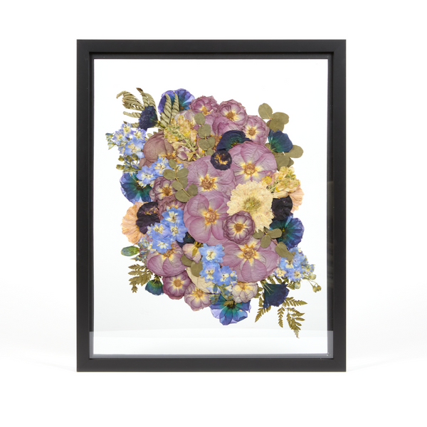 Floral preservation pressed flower frame with purple, blue, and white pressed florals on a natural archival grade background. 16x20 black wood frame design. 