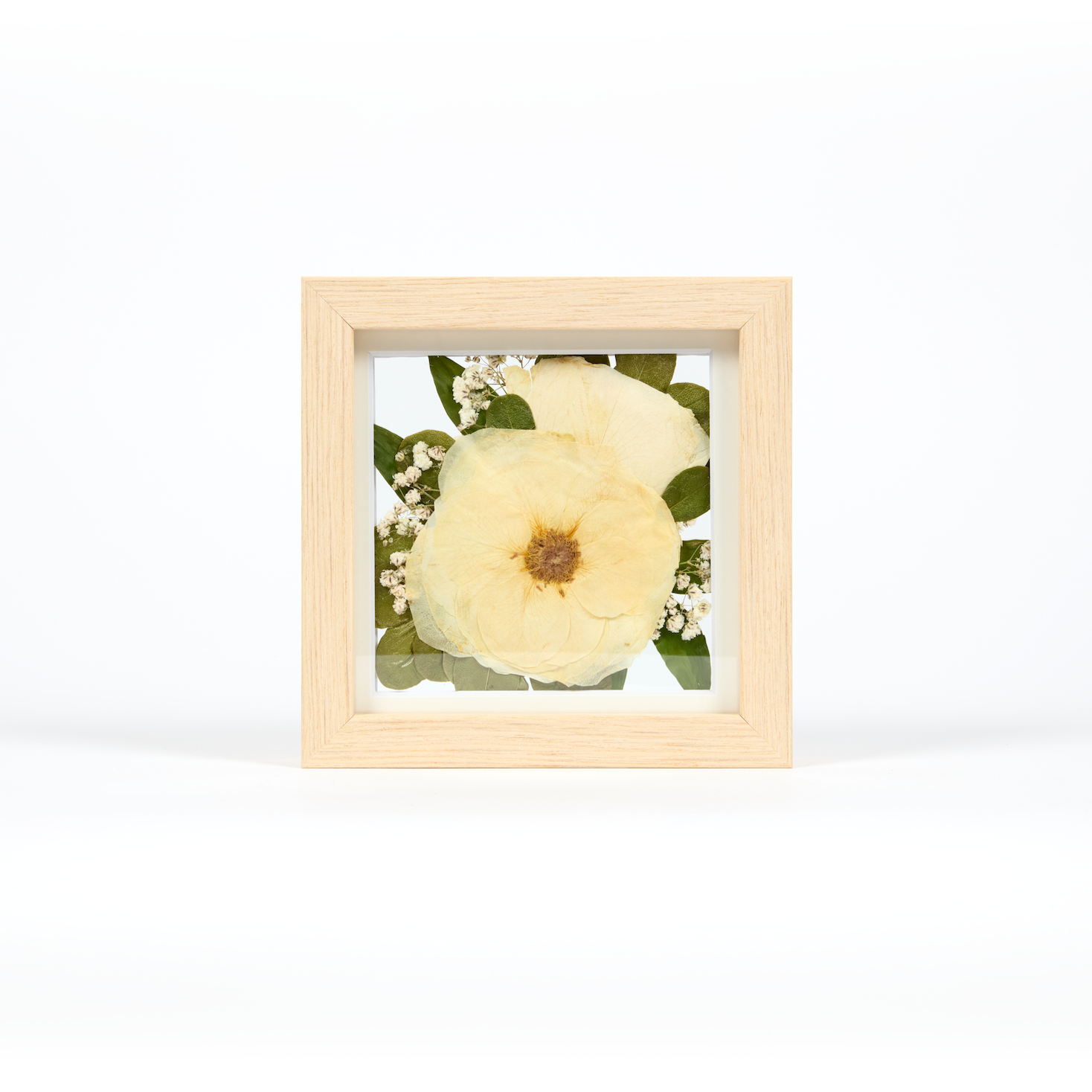 Small pressed floral art frame with white roses, baby's breath, and greenery. A 6x6 display of preserved wedding flowers. 