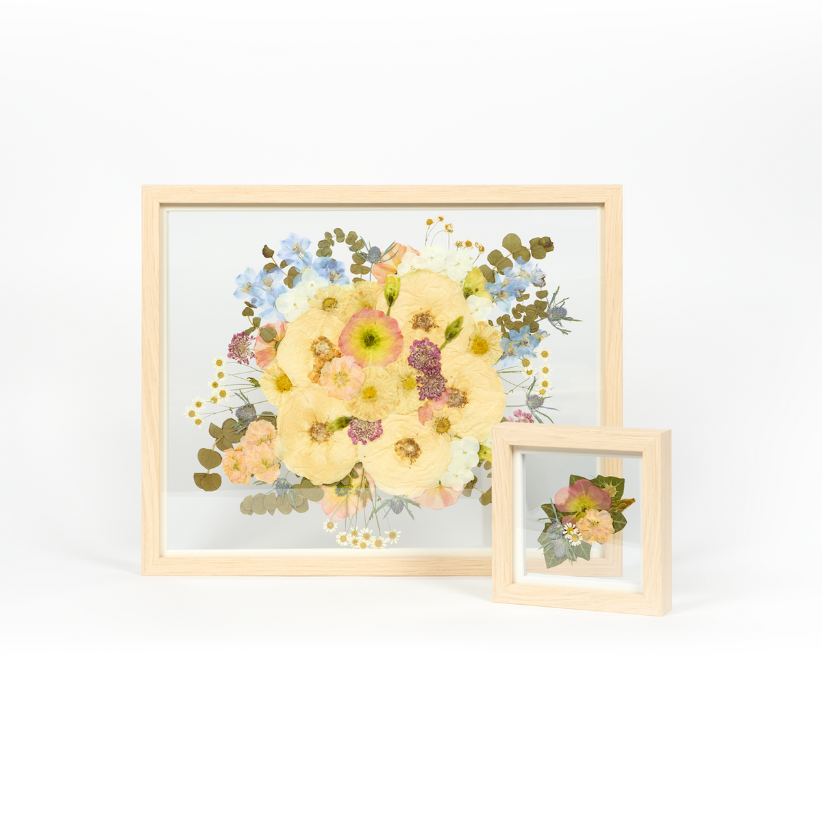 Wedding bouquet preservation set in natural wood with colorful pastel toned pressed florals. 