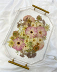 A spring-toned wedding bouquet preserved in a resin serving tray with gold handles.