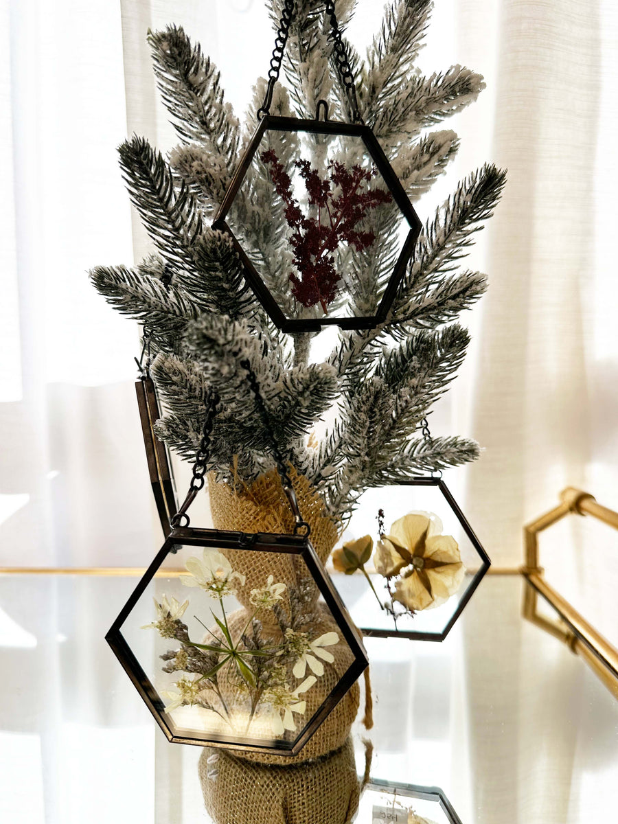 Hanging pressed flower frame ornaments on a mini tree.