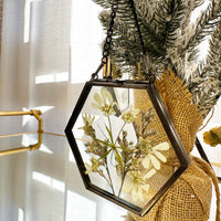 Hanging pressed flower frame ornaments on a mini tree.