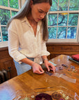 A woman creating a pressed flower bookmark at a class