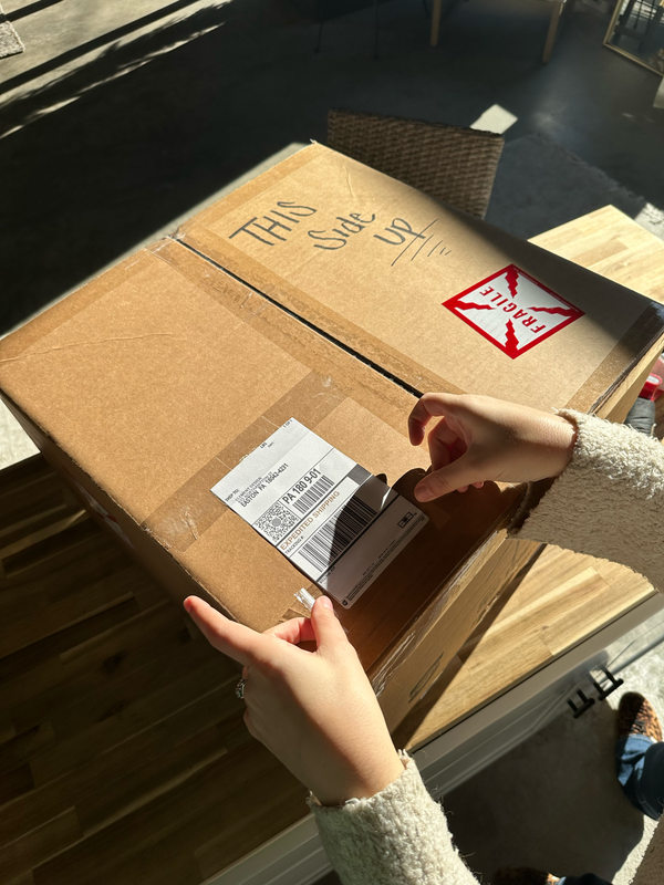 A woman puts a shipping label on her bouquet box before she sends it off to be preserved.