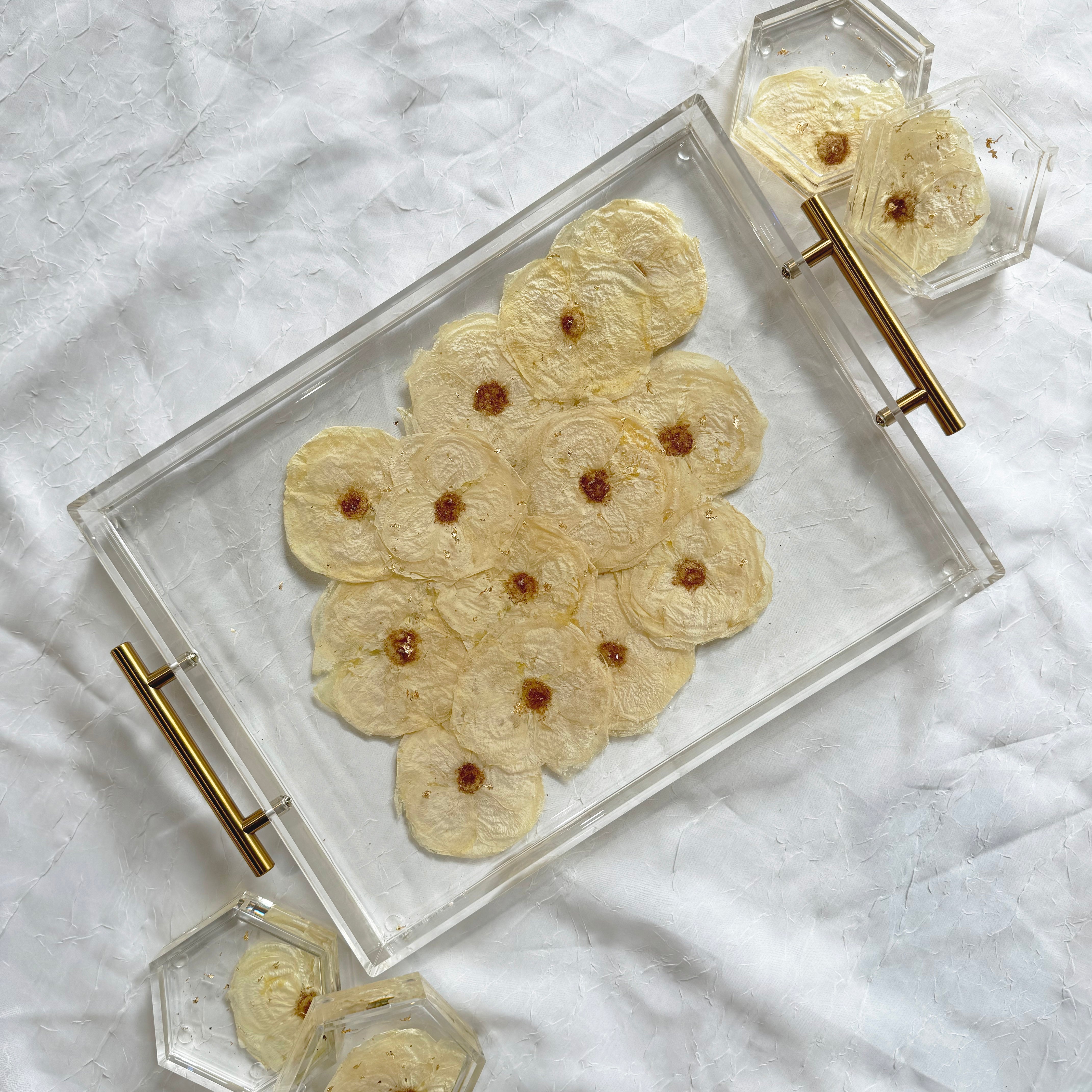 Rectangle resin tray with gold handles and four hexagon resin coasters, featuring pressed white roses and silver metallic flakes on a white background.