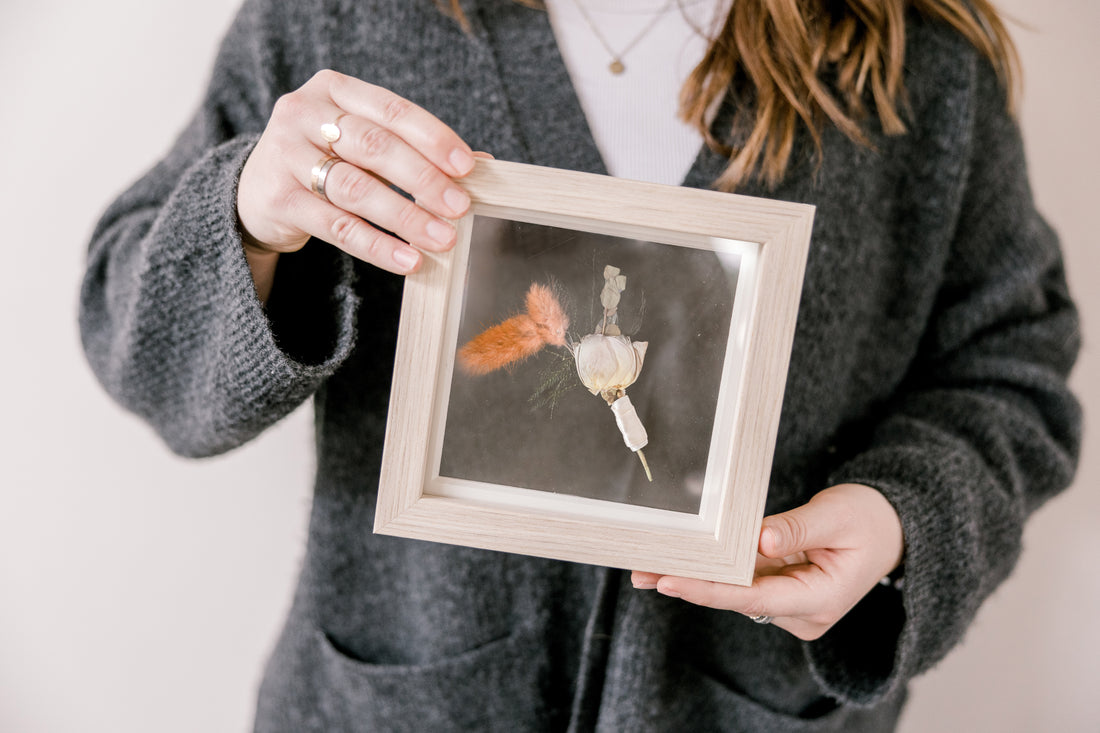 6x6, mini natural wood frame with a pressed boutonniere being held.