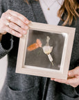 6x6, mini natural wood frame with a pressed boutonniere being held.