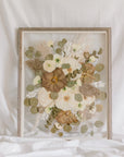 A fall-toned pressed wedding bouquet in a barn wood frame. 