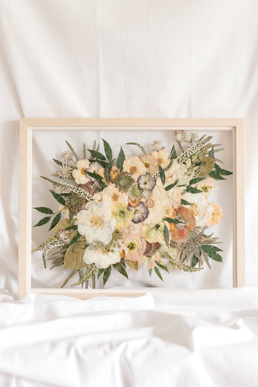 Wedding flowers preserved in time in a floating glass frame made of natural wood. 