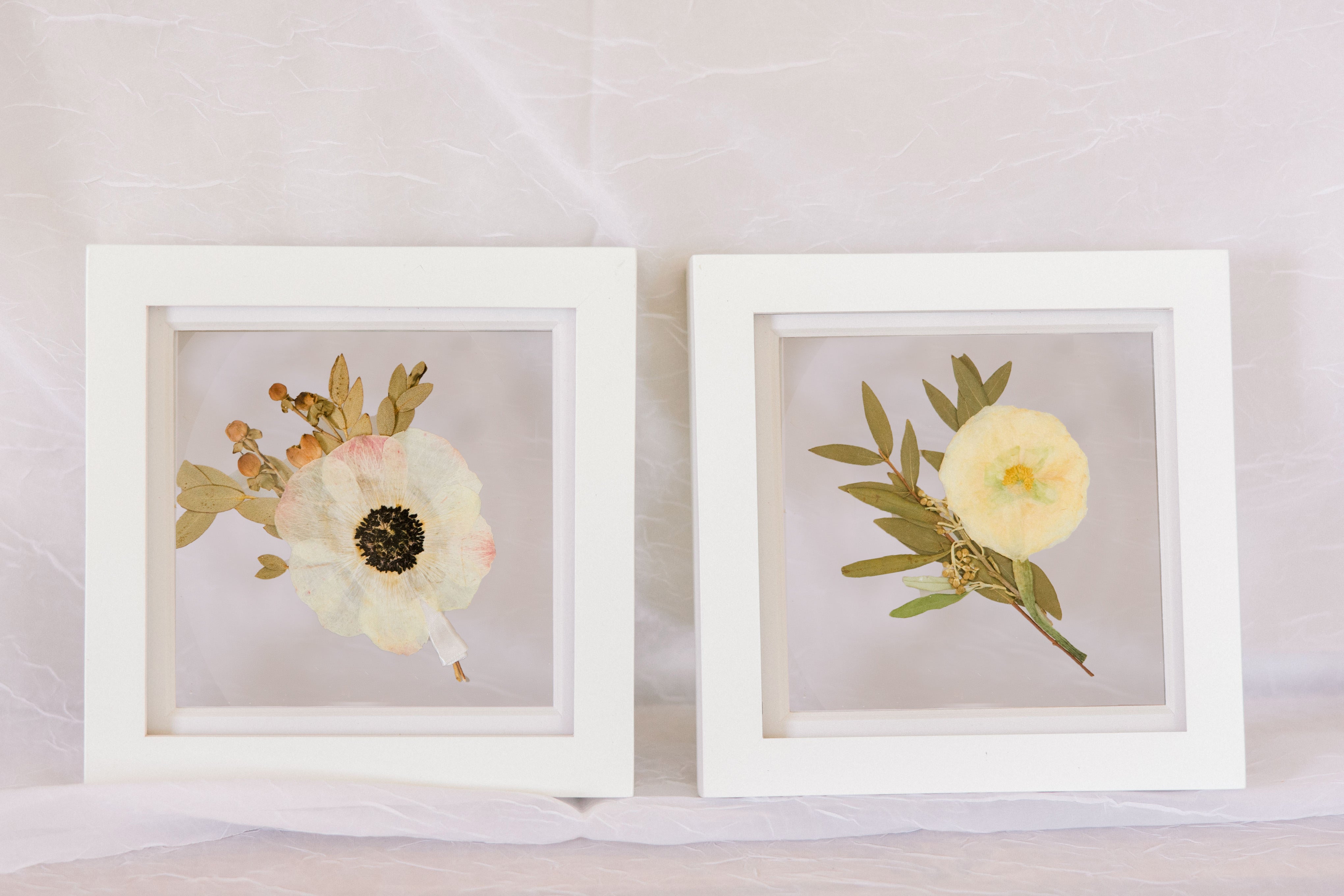 Two 6x6" mini white wood frames with a pressed boutonniere