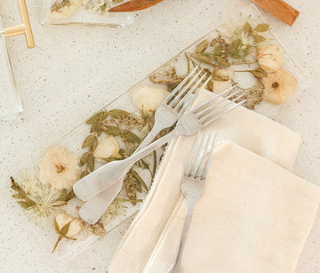 Pressed white and green flowers in a display tray made by the Pressed Bouquet Shop.