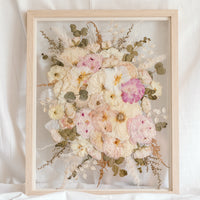 A beautiful wedding bouquet pressed and framed in a natural wood floating frame. 