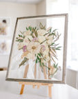 A white and pink wedding bouquet that has been pressed with a boutonniere inside a barn wood frame.