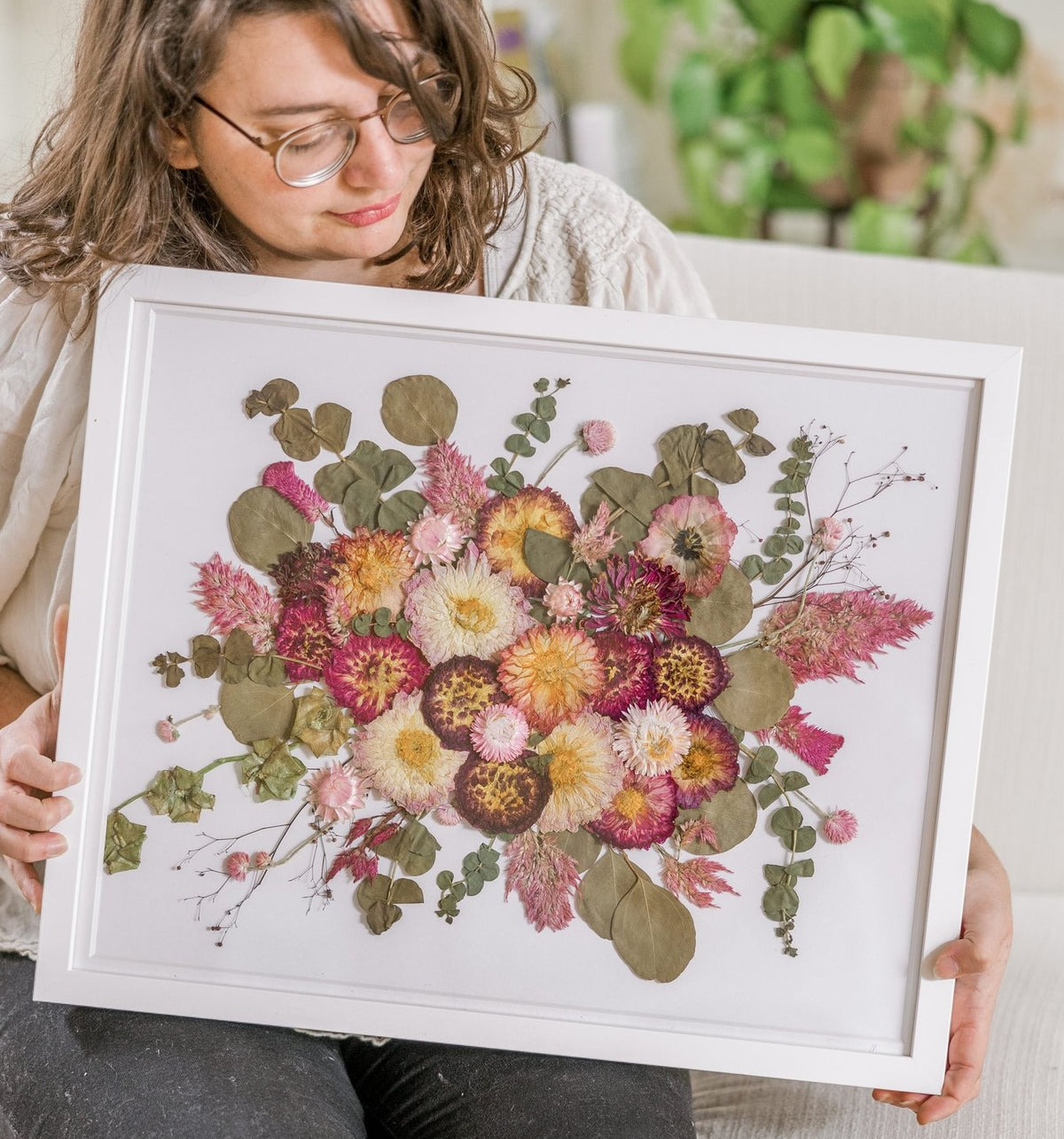 A woman holds her preserved wedding bouquet frame from Element Design.