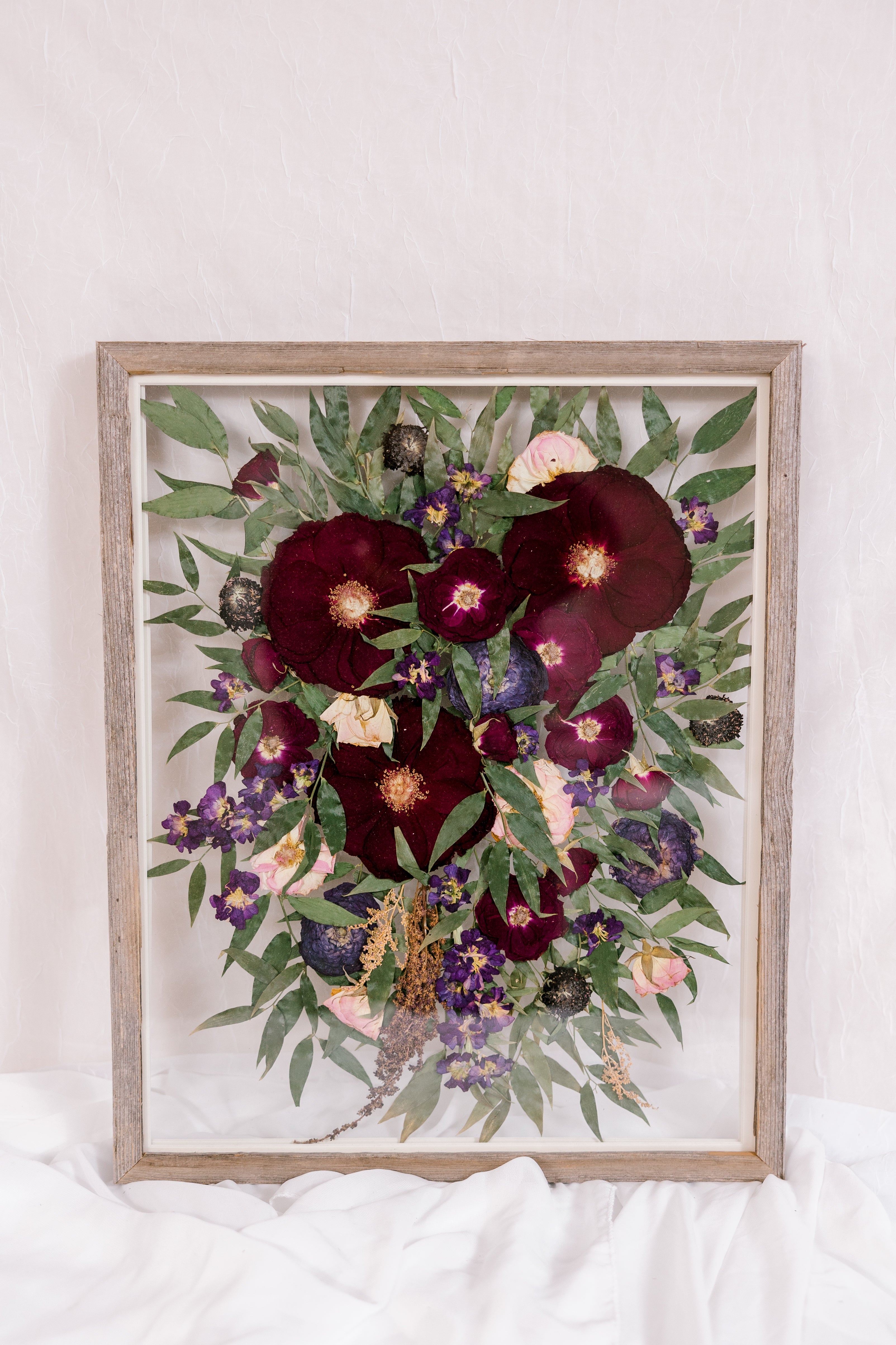 A cascading bouquet that was pressed into a barn wood frame. 