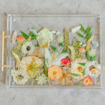 Pressed flower resin serving tray with gold handles in a field style design.