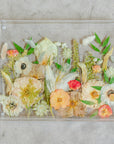 Pressed flower resin serving tray with gold handles in a field style design.