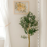 A bouquet of flowers that have been pressed and framed are hung inside of a child's room on the wall. 
