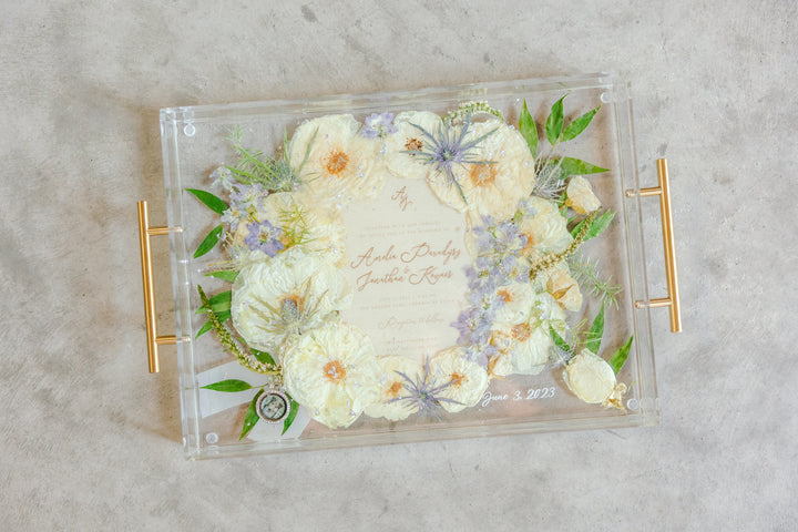 Serving tray with pressed flowers from a wedding bouquet, including a wedding invitation. 