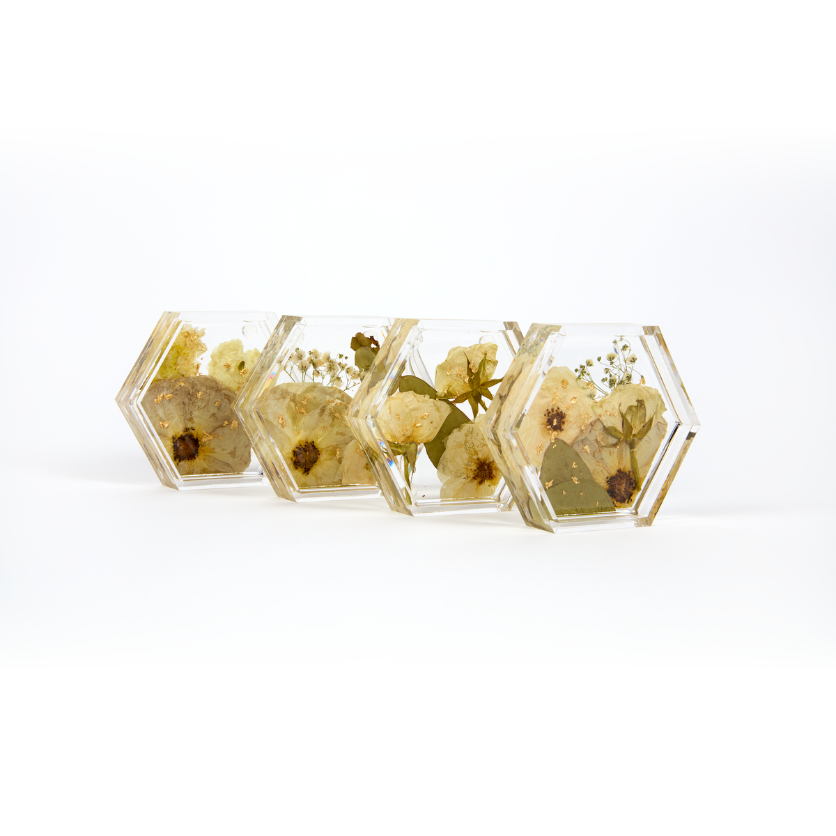 Preserved flowers in resin coasters, a set of four. Hexagon shape with gold metallic flakes added. 